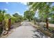 Long driveway leading to a property entrance with decorative metal gates and lush greenery at 24805 Nova Ln, Punta Gorda, FL 33980