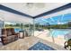 Cozy seating area overlooks the screened-in pool and serene lake views at 24805 Nova Ln, Punta Gorda, FL 33980