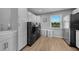 Bright laundry room with modern appliances, white cabinetry, and convenient sink area at 24805 Nova Ln, Punta Gorda, FL 33980