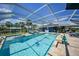 Enclosed pool with shimmering water and comfortable lounge seating in a beautiful backyard at 24805 Nova Ln, Punta Gorda, FL 33980