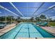 Enclosed outdoor pool area featuring scenic lake views and lounge seating at 24805 Nova Ln, Punta Gorda, FL 33980