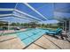 Enclosed outdoor pool area with scenic lake views and lounge seating at 24805 Nova Ln, Punta Gorda, FL 33980