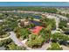 An aerial view of a single-Gathering home encircled by trees, near a lake and waterway at 26 Saint Croix Way, Englewood, FL 34223