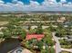 Beautiful lake view home with a red roof, screened-in pool, mature trees, and lush surroundings in a desirable community at 26 Saint Croix Way, Englewood, FL 34223