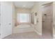 Bright bathroom featuring a soaking tub with decorative glass block window and walk-in shower at 26 Saint Croix Way, Englewood, FL 34223