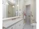 Bathroom with a walk-in shower, grey tile floor, white cabinets, and pendant lighting at 26 Saint Croix Way, Englewood, FL 34223