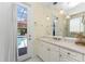 Bright bathroom with a white vanity, neutral counter and pendant lights, plus a door to the pool area at 26 Saint Croix Way, Englewood, FL 34223