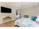 Light-filled bedroom offering hardwood floors, mounted television, and sliding door to patio at 26 Saint Croix Way, Englewood, FL 34223