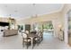 Open-concept dining and living room with neutral tones, tile floors, water view, and ample natural light at 26 Saint Croix Way, Englewood, FL 34223