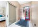 Bright entryway features red front door, neutral paint, tile floors, and access to a bedroom through a sliding door at 26 Saint Croix Way, Englewood, FL 34223
