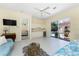 Living room with tile floors, an adjacent kitchenette, and sliding glass doors to the outdoor pool at 26 Saint Croix Way, Englewood, FL 34223