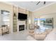 Bright living room with tile floors, fireplace, built in shelving, water view, and access to patio area at 26 Saint Croix Way, Englewood, FL 34223
