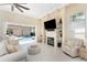 Bright living room with fireplace, built-in shelving, tile floors, and access to screened-in pool area at 26 Saint Croix Way, Englewood, FL 34223