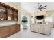 Bright and open living room with built-in shelves, wet bar, tile floors, and views of the pool area at 26 Saint Croix Way, Englewood, FL 34223