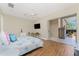 Bright main bedroom with wood floors, ceiling fan, and sliding doors to the screened lanai at 26 Saint Croix Way, Englewood, FL 34223