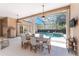 Outdoor dining area leads to a screened-in pool with lush landscaping at 26 Saint Croix Way, Englewood, FL 34223