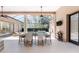 A bright covered patio with an outdoor dining area overlooking a screened-in pool and lush backyard at 26 Saint Croix Way, Englewood, FL 34223