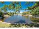 Picturesque pond view framed by mature trees, offering a tranquil and scenic backdrop at 26 Saint Croix Way, Englewood, FL 34223