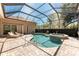 Relaxing screened-in pool with spa, poolside seating, and lush greenery in a private backyard at 26 Saint Croix Way, Englewood, FL 34223