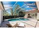 Relaxing poolside view of a screened-in pool and spa with poolside lounge chairs at 26 Saint Croix Way, Englewood, FL 34223