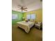 Cozy bedroom featuring a ceiling fan, neutral carpeting, and abundant natural light from two large windows at 2650 Colonade Ln, North Port, FL 34286
