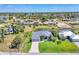 Aerial view of home featuring a well-manicured lawn, mature trees, and community canals at 27 Sportsman Cir, Rotonda West, FL 33947