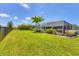 Beautifully landscaped backyard with lush green lawn, garden beds, and mature trees at 27 Sportsman Cir, Rotonda West, FL 33947
