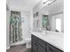 Bright bathroom featuring a shower over bath, decorative shower curtain, vanity with storage and tiled walls at 27 Sportsman Cir, Rotonda West, FL 33947