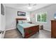 Well-lit bedroom features wood-look tile flooring, a window, a ceiling fan, and a wood bed frame at 27 Sportsman Cir, Rotonda West, FL 33947