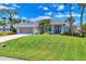 Charming single-story home boasts a beautifully manicured lawn and tropical landscaping, creating a welcoming curb appeal at 27 Sportsman Cir, Rotonda West, FL 33947