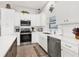 Well-lit kitchen offers white cabinets, stainless steel appliances, and neutral backsplash at 27 Sportsman Cir, Rotonda West, FL 33947