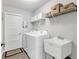 Functional laundry room including a washer, a dryer, sink, ample storage, and tile floors at 27 Sportsman Cir, Rotonda West, FL 33947