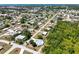 Aerial view of a home with a screened pool, surrounded by lush greenery and neighborhood streets at 270 E Wentworth St, Englewood, FL 34223