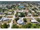 This aerial view showcases a home with a screened pool in a neighborhood close to a central lake feature at 270 E Wentworth St, Englewood, FL 34223
