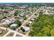 Aerial view of a home with a screened pool, surrounded by lush greenery and neighborhood streets at 270 E Wentworth St, Englewood, FL 34223