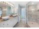Modern bathroom featuring double vanities, granite countertop and a glass enclosed shower with tiled walls at 270 E Wentworth St, Englewood, FL 34223