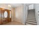 Home foyer featuring a wood door and staircase with neutral-toned walls at 270 E Wentworth St, Englewood, FL 34223
