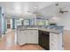 Kitchen island featuring white cabinets, gray countertops, and a breakfast bar, with view to the living area at 270 E Wentworth St, Englewood, FL 34223