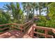 Charming wooden dock surrounded by lush greenery and palm trees at 3246 Yukon Dr, Port Charlotte, FL 33948