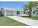 Well-maintained single-Gathering home featuring a metal roof and a lush, green front yard with a swaying palm tree at 3246 Yukon Dr, Port Charlotte, FL 33948