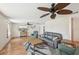 Comfortable living room featuring hardwood floors, ceiling fans, and a cozy seating arrangement with a leather sofa at 3246 Yukon Dr, Port Charlotte, FL 33948