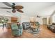 Spacious living area with hardwood floors, ceiling fans, and an open layout that flows into the kitchen and dining room at 3246 Yukon Dr, Port Charlotte, FL 33948