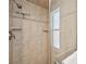 Tile shower featuring a glass door, window, and adjustable shower head at 3246 Yukon Dr, Port Charlotte, FL 33948