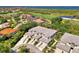 Stunning aerial view of townhomes with tile roofs, lush landscaping, and a beautiful golf course and pond in the background at 3433 Grand Vista Ct # 102, Port Charlotte, FL 33953