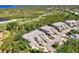 A captivating aerial view showcases townhomes surrounded by lush greenery, a scenic golf course, and tranquil ponds at 3433 Grand Vista Ct # 102, Port Charlotte, FL 33953