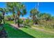 The backyard boasts green grass, mature trees, and lush landscaping at 3433 Grand Vista Ct # 102, Port Charlotte, FL 33953
