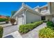 Side view of a two-story townhouse, showcasing well-kept landscaping, neutral exterior, and an attached two-car garage at 3433 Grand Vista Ct # 102, Port Charlotte, FL 33953