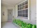 Charming front porch with a decorative door wreath, pineapple accent, and lush green ferns adding a touch of nature at 3433 Grand Vista Ct # 102, Port Charlotte, FL 33953