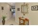 Inviting hallway with tiled flooring, decorative mirror, and table; leads to the kitchen and open-concept living area at 3433 Grand Vista Ct # 102, Port Charlotte, FL 33953