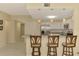 Open kitchen featuring stainless steel appliances, white cabinets, breakfast bar with stools, and seamless flow to living spaces at 3433 Grand Vista Ct # 102, Port Charlotte, FL 33953